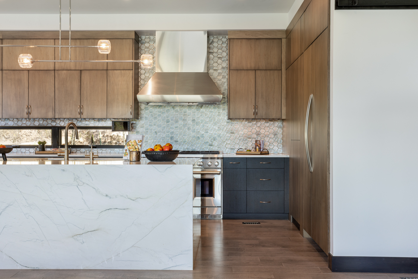 Range wall with hexagon glass tile and waterfall island