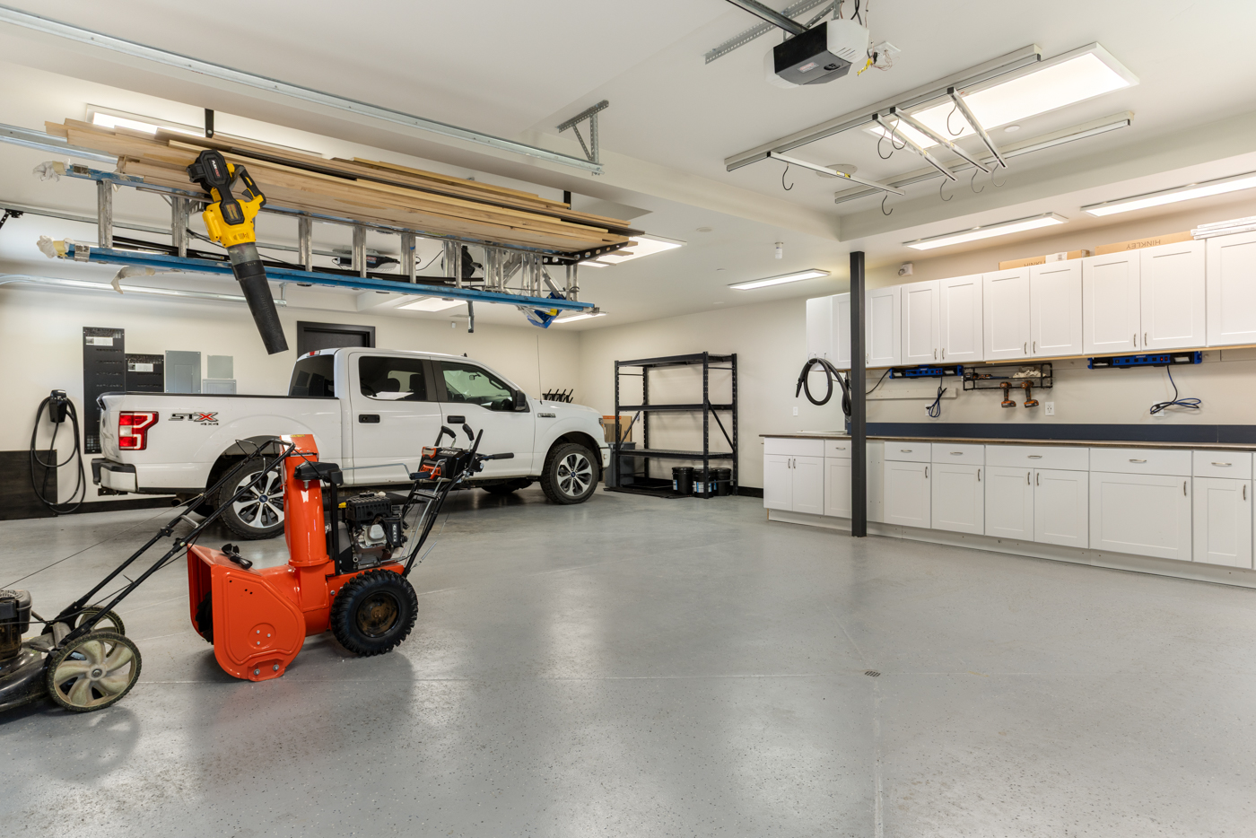Oversized garage with built-in cabinetry and EV charger