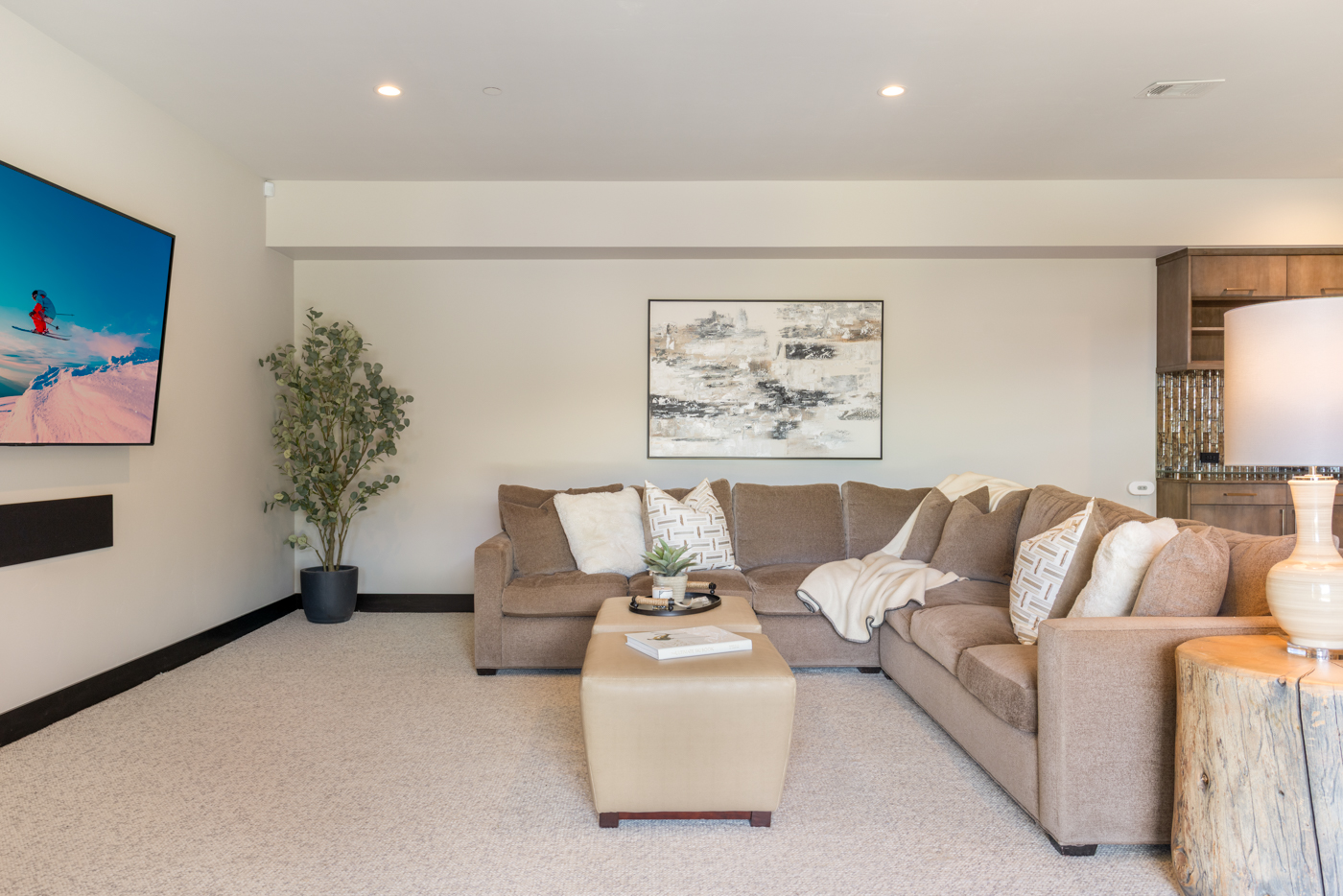 Family room open to the wet bar with layered lighting