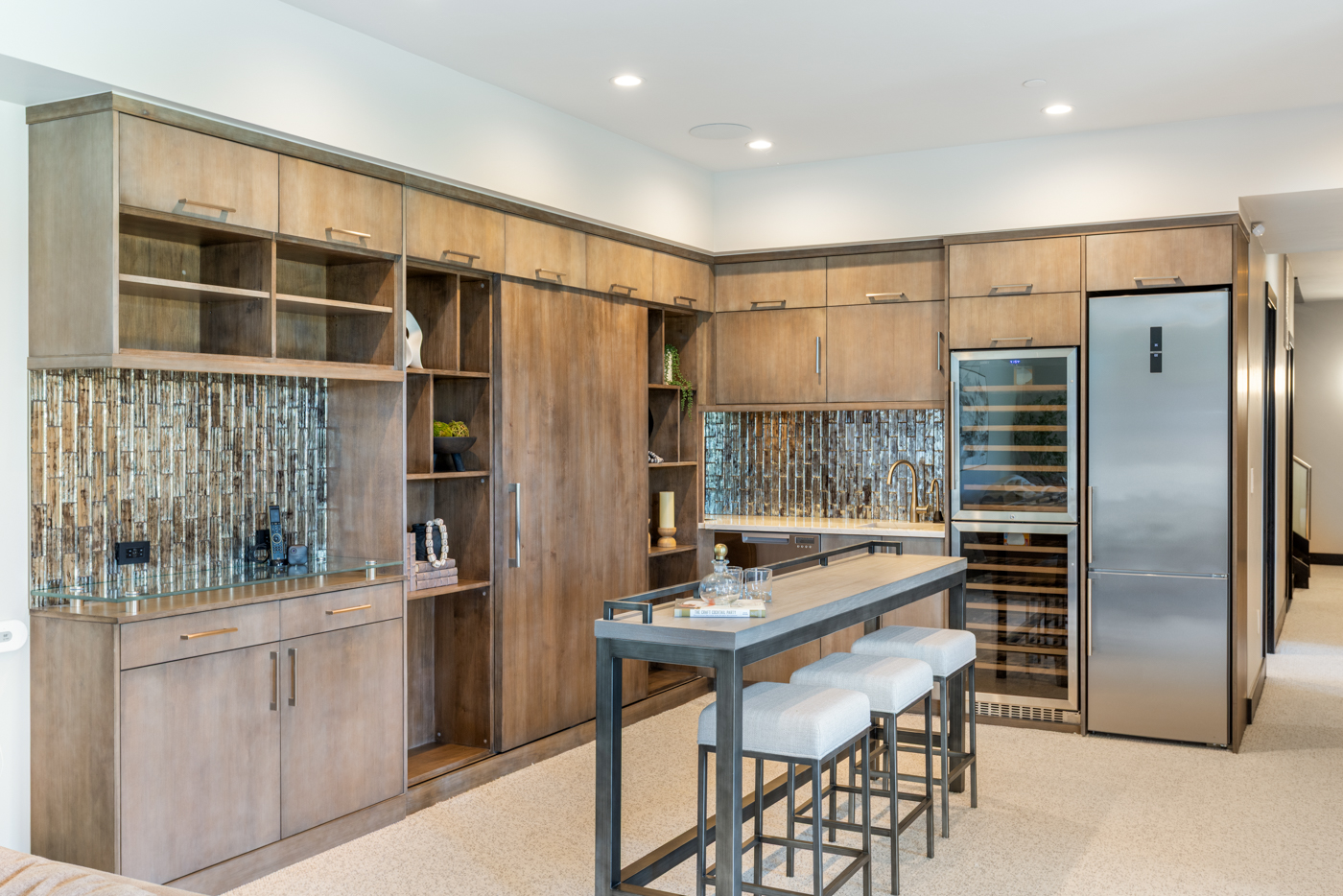 Bar island with three stools, wine fridge, and beverage refrigerator