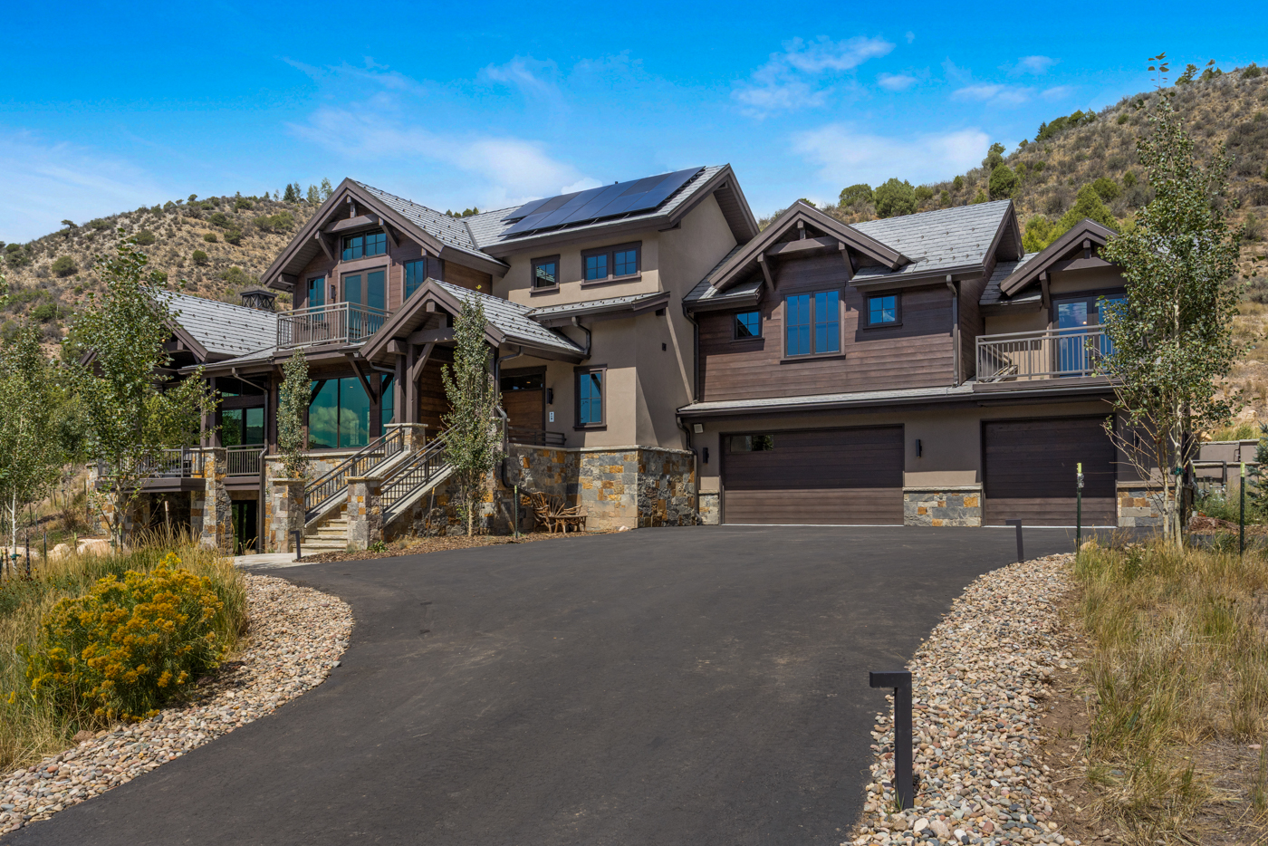 Front elevation with stone, timber, and heated circular drive