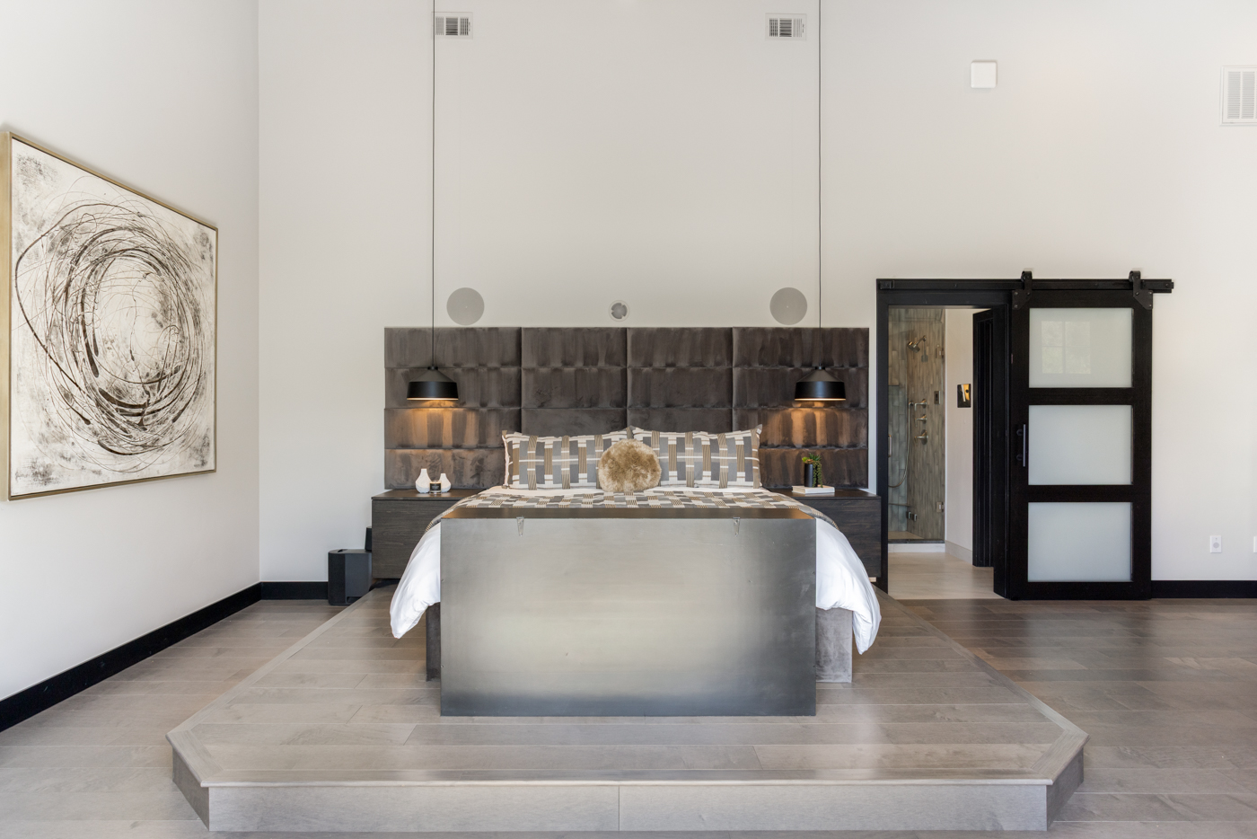 Primary suite with upholstered wall and elevated platform bed