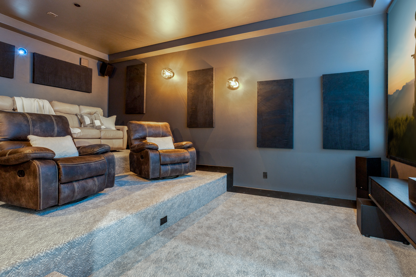 Home theater with tiered recliner seating and acoustic panels