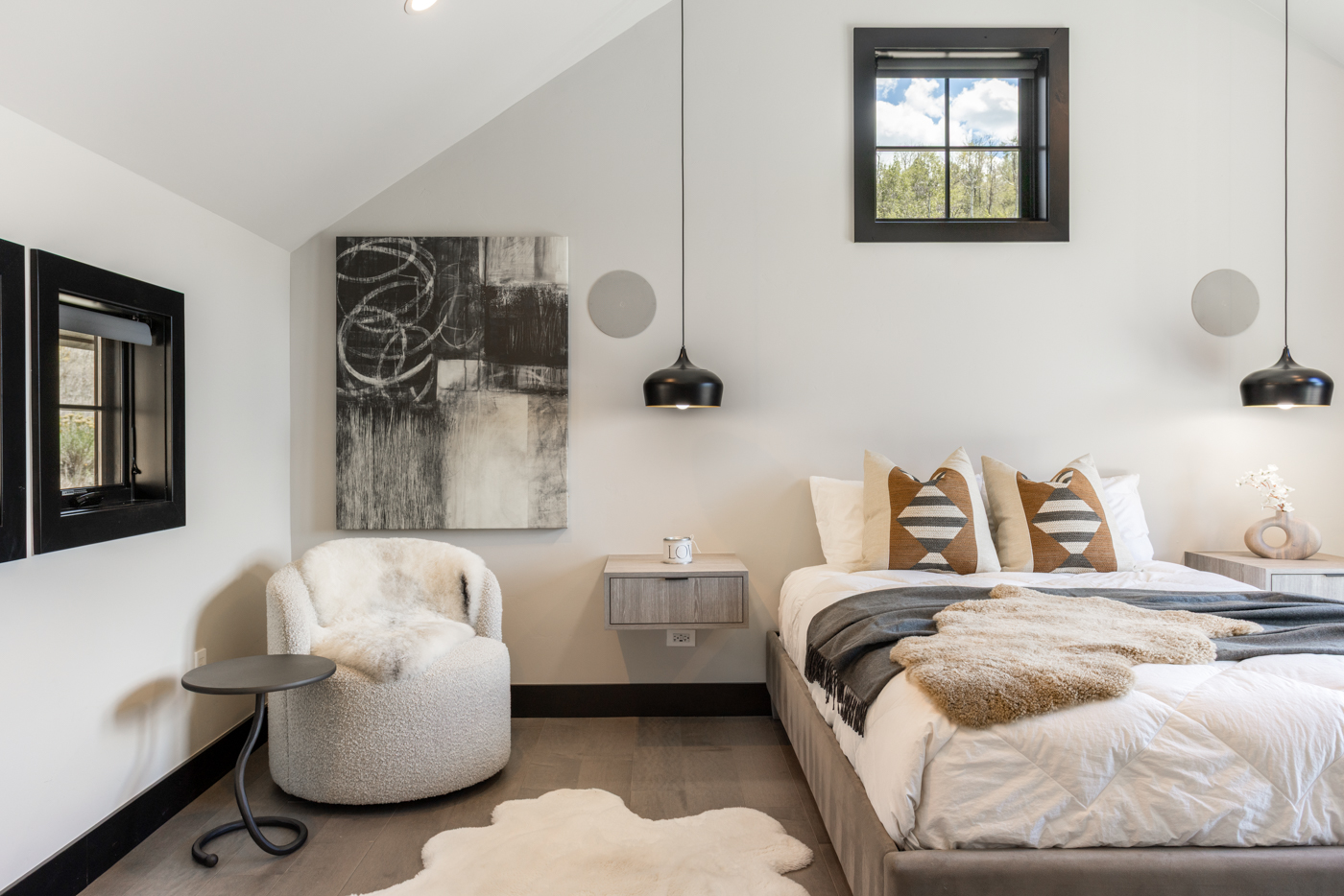 Upper guest bedroom with vaulted ceiling and pendant lighting